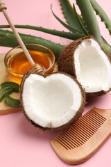 Hair treatment. Fresh coconut, honey, comb and aloe leaves on pink background, closeup
