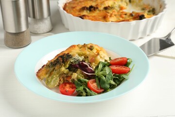 Tasty vegetable casserole and salad on white wooden table, closeup