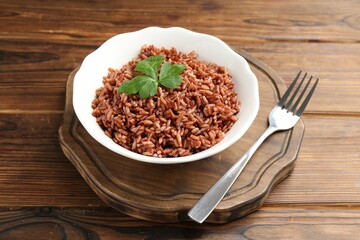 Delicious brown rice with parsley served on wooden table