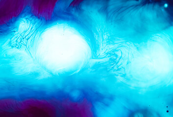 Abstract background with swirling patterns in purple and blue colors. Photo is reminiscent of marble texture or the movement of ink in water. Bright white spots create an effect of glow and depth. 