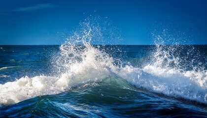 Fototapeta premium Waves Crash Against the Shore Under a Clear Blue Sky Creating a Refreshing Coastal Atmosphere