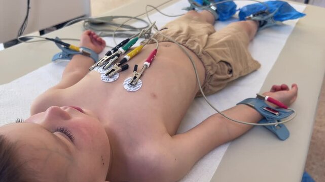 A young patient is currently connected to vital sign monitors which are used for a thorough health assessment