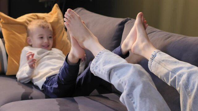 Children playing on sofa with bare feet raised