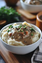 Creamy mashed potatoes with savory mushroom gravy and fresh parsley in a white bowl on a wooden board