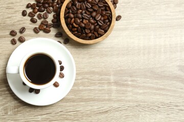Cup of coffee with coffee beans on wooden background