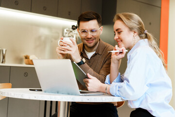 Two professionals collaborate over laptop in a modern workspace during a productive day