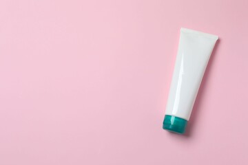 Natural cosmetic products. Cosmetic tube a pink background, top view
