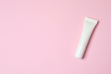 Natural cosmetic products. Cosmetic tube a pink background, top view