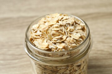 Composition with oatmeal flakes on wooden background. Cooking breakfast