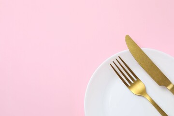White empty plate with cutlery on a colored background