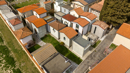 Aerial view of small chapels in a countryside cemetery. In each chapel there are dead people buried...