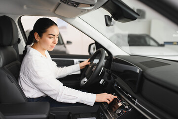 Young woman choosing a car at car showroom
