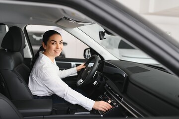 Cheerful female client of car dealership
