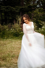 Fototapeta premium A stunning bride gracefully dances and twirls in a spring park