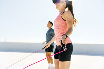 Jumping rope workout session on a sunny rooftop with fitness enthusiasts enjoying exercise