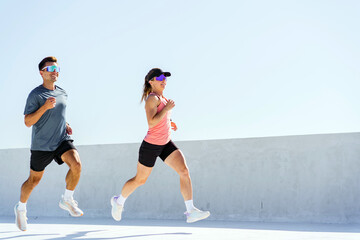 Runners enjoy a sunny day exercising on a rooftop track in a modern urban setting