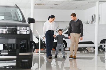 Happy family buying a new car at the car showroom
