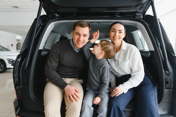 Happy family buying a new car at the car showroom
