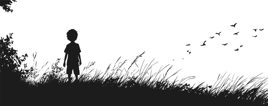 Silhouette of young boy standing on hill with birds flying in sky.