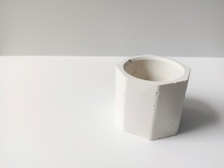 Mini cement pot for white decorative flowers, isolated on white background. closeup