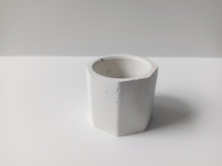 Mini cement pot for white decorative flowers, isolated on white background. closeup