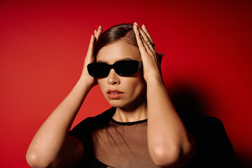 Elegant young woman exuding confidence and style in a chic urban setting under red lights