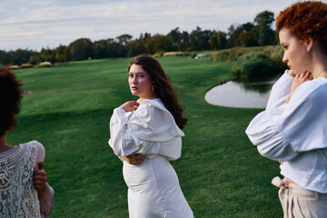 Stylish women embracing nature while showcasing summer fashion in a serene park setting