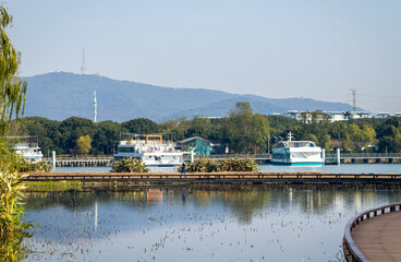 Peaceful Lakeside Scene with Boats and Scenic Mountains
