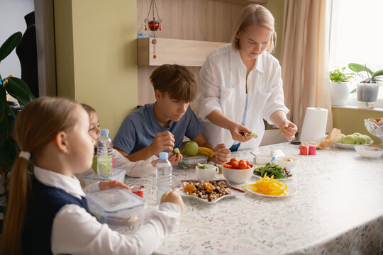 A family gathers around the table to organize a nutritious breakfast, ensuring children are ready for their school day.