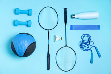 Different sports equipment and water bottle on light blue background, flat lay