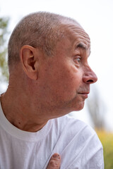 Obraz premium skeptical mature senior man Outdoors, male face shows frustration, skepticism, and emotional pain close-up, Female model expressing frustration and doubt with tense pose