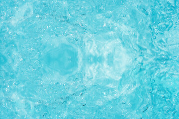 Blue water with ripples on the surface. Defocus blurred transparent blue colored clear calm water surface texture with splashes and bubbles. Water waves with shining pattern texture background.