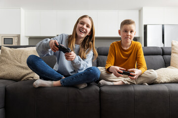 Siblings enjoying their leisure time playing video games together