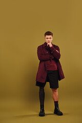 Fototapeta premium Confident young man modeling fashion with a prosthetic leg in the studio