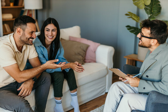 Young couple talking to psychologist on therapy session