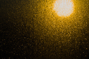 Blurred bokeh light sparkle on golden black background