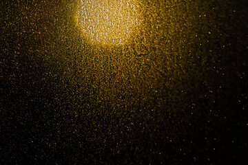 Blurred bokeh light sparkle on golden black background