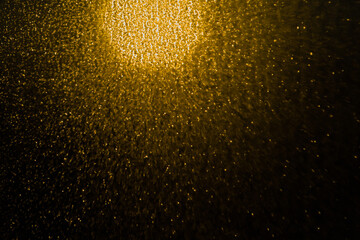 Blurred bokeh light sparkle on golden black background