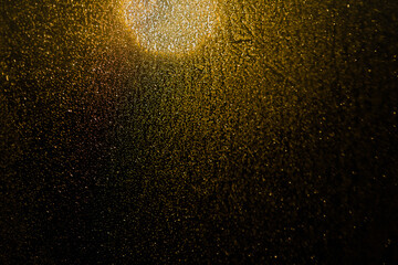 Blurred bokeh light sparkle on golden black background