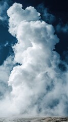 Billowing steam clouds rise from geothermal vents in a clear sky, creating a stunning natural display during daylight hours
