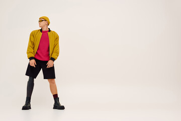 Handsome young man with prosthetic leg shows modern fashion in a stylish studio