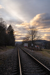 Fototapeta premium Railway Tracks Leading to the Horizon at Sunset