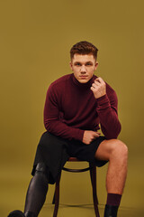 Handsome young man confidently poses in stylish attire showcasing his prosthetic leg