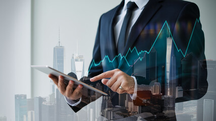 Businessperson using tablet, overlaid with cityscape and growth graph, symbolizing financial success and urban development, showcasing modern business strategies