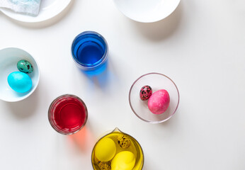 Coloring eggs for Easter celebration on white table