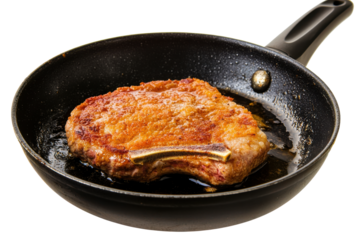 Juicy pork chop sizzling in a black frying pan with oil