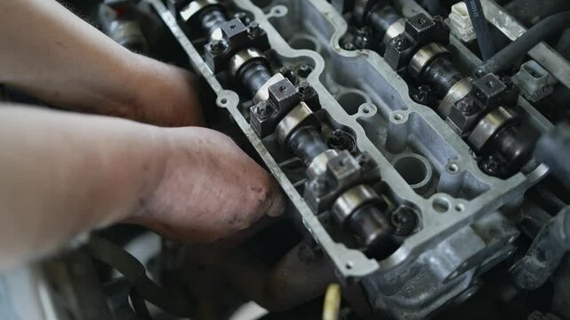 Mechanic Repairing Car Engine Camshaft in Workshop