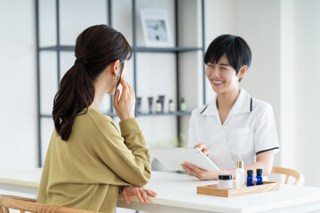 Obraz premium 若い女性の接客をするエステサロンのセラピスト