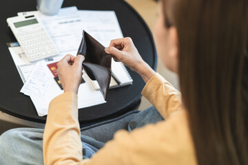 debts in first jobber, Young woman open wallet find it empty with many invoice and credit card on the table