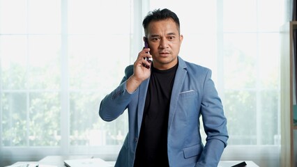 Asian Businessman Talking on Smartphone in Modern Office